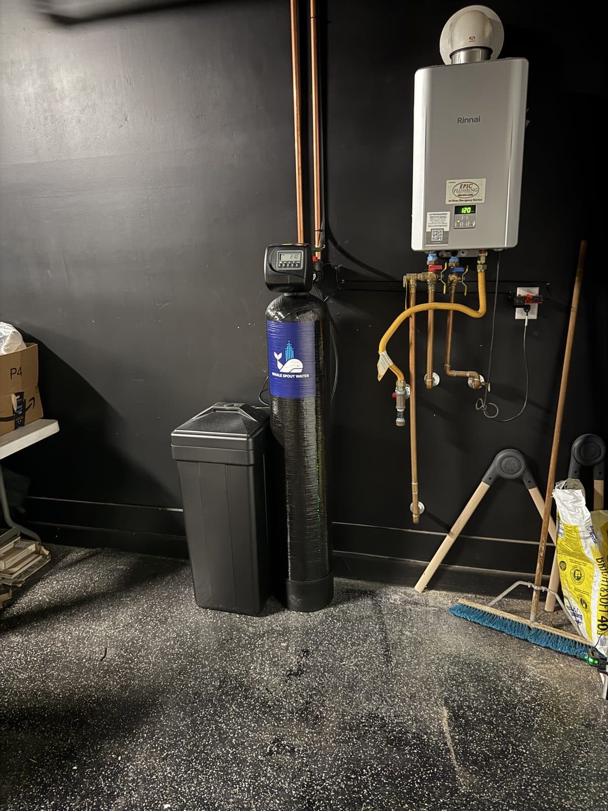 Water softener connected to a new home's copper softener loop beside a tankless water heater