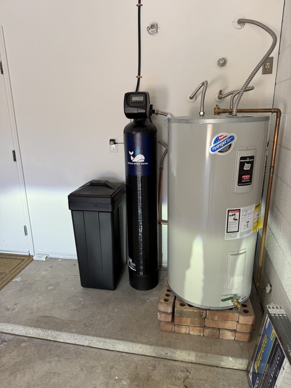 Water softener installed beside a tank water heater to protect it from hard water scale