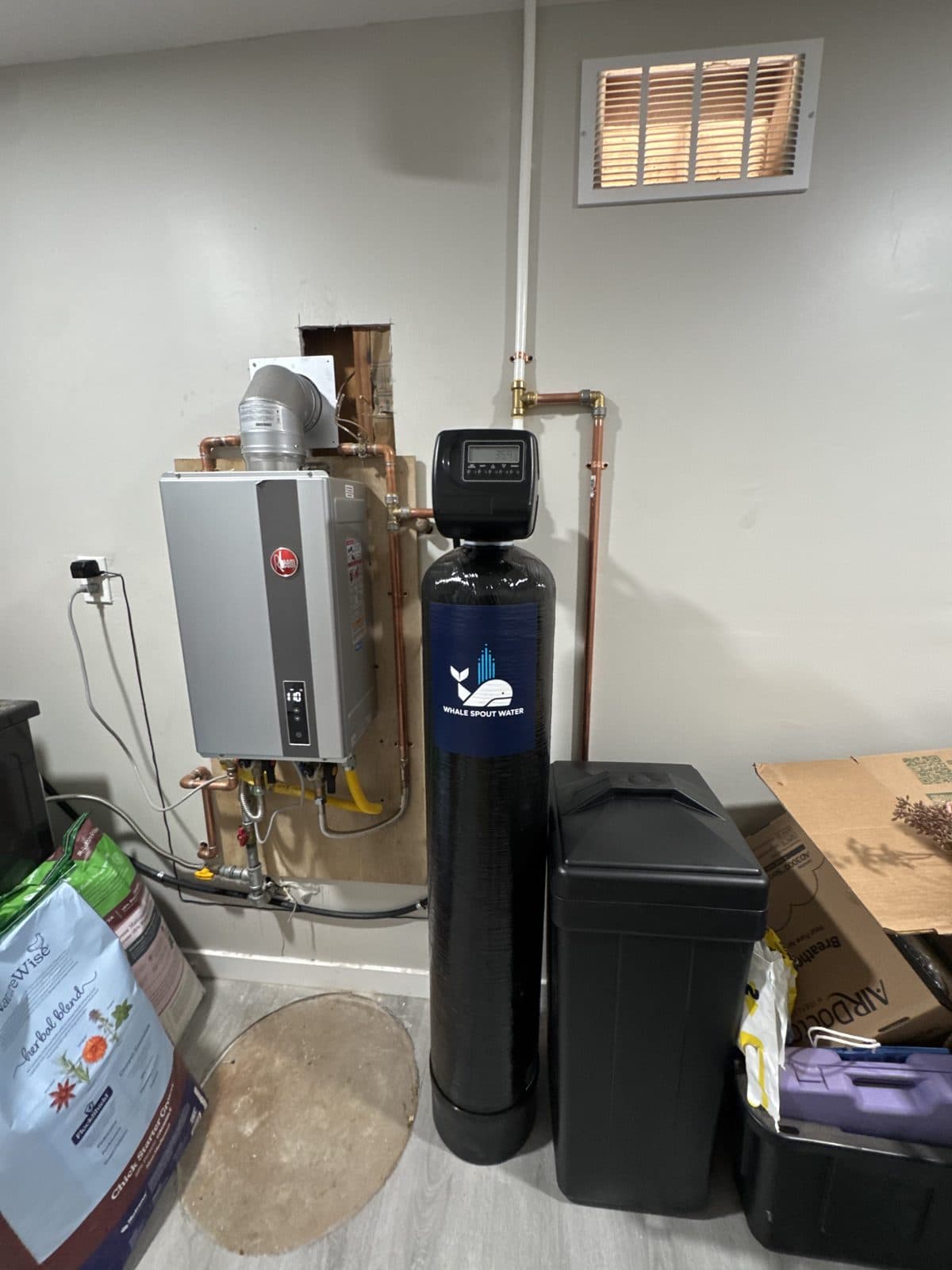 Whole-home water softener installed next to a tankless water heater, part of the Salt Softener + RO Bundle priced at $3,399 installed