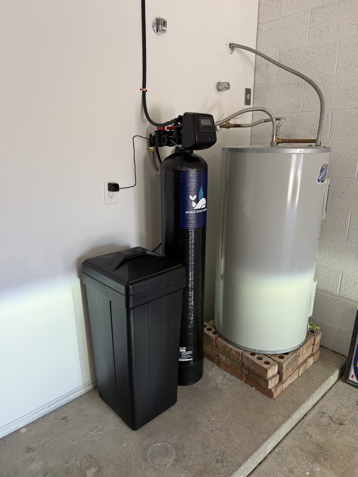 Whale Spout Water softener and brine tank installed next to a garage water heater